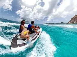 Two guests riding a jet ski on Caribbean water